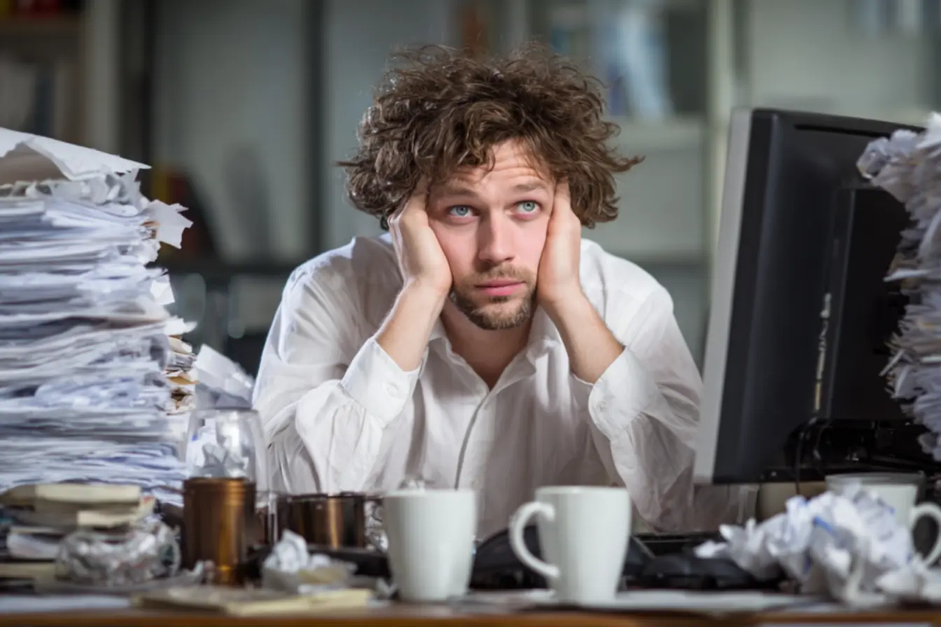 Pessoa sentada em um ambiente organizado, concentrada em uma tarefa, com um plano visível, simbolizando a conquista de um dia com propósito e a execução da intenção em ação concreta