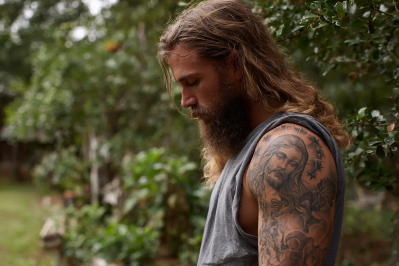 Tatuagem de Jesus Cristo com flores e elementos delicados de fé